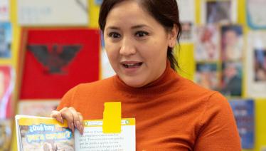 Teacher holding up Spanish book about penguins